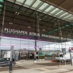 Berlim Brandenburg Willy Brandt Aeroporto Terminal 1 entrada com carros estacionados do lado de fora.