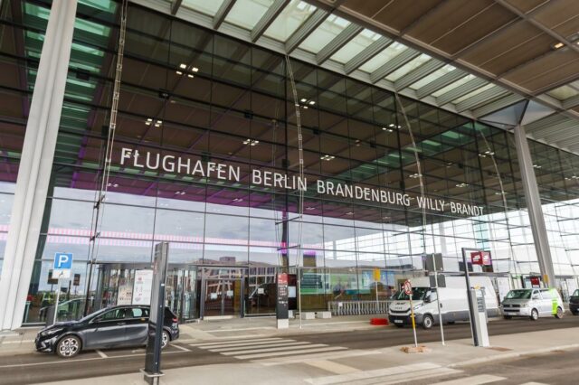 Berlim Brandenburg Willy Brandt Aeroporto Terminal 1 entrada com carros estacionados do lado de fora.