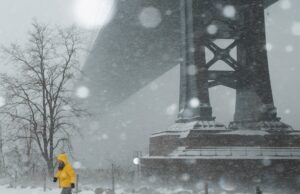 Tempestade de inverno causa mortes, cortes de energia e cancelamentos de voos nos EUA Uma pessoa passa por uma delicatessen em tempo de neve