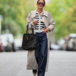 BERLIM, ALEMANHA - 25 DE NOVEMBRO: Laura Noltemeyer é vista vestindo um cardigã de malha boucl√© creme com textura estruturada e fecho de botão dourado da Massimo Dutti; calça jeans reta azul claro com desbotamento suave em corte clássico da Zara; botas plataforma de couro marrom escuro e cinza com detalhes em monograma e sola de borracha grossa e detalhes em camurça da Louis Vuitton; uma bolsa de couro branco estruturado com alça superior em tecido intrecciato e silhueta trapézio chamada ‚ÄúIntrecciato Tote‚Äù da Bottega Veneta; brincos grossos de ouro escultural da Zara; seu cabelo castanho escuro está solto, liso e repartido ao meio em 25 de novembro de 2025 em Berlim, Alemanha. (Foto de Moritz Scholz/Getty Images)