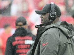 Todd Bowles demite vários treinadores em grande reforma dos Buccaneers O técnico do Tampa Bay Buccaneers, Todd Bowles, usando um fone de ouvido e um boné preto com logotipo, assistindo da linha lateral.