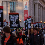 Um manifestante segura uma placa enquanto protestava do lado de fora da Casa Branca em Washington, sábado, 15 de novembro de 2025. (AP Photo/Jose Luis Magana)