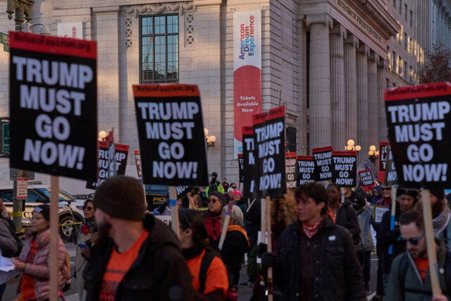 Trump está sendo derrotado na batalha pela opinião pública Um manifestante segura uma placa enquanto protestava do lado de fora da Casa Branca em Washington, sábado, 15 de novembro de 2025. (AP Photo/Jose Luis Magana)
