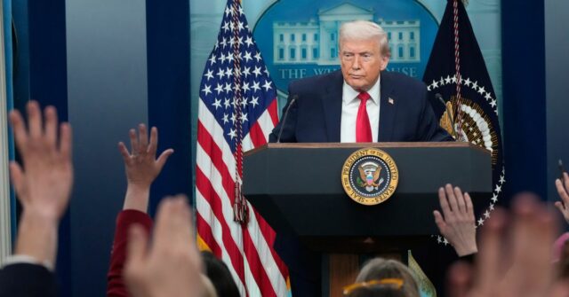 Os repórteres levantam as mãos enquanto o presidente Donald Trump fala durante uma coletiva de imprensa na Casa Branca.