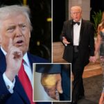 Donald Trump falando aos repórteres, com a mão direita levantada e o dedo indicador apontado para cima.