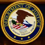 FILE - The U.S. Department of Justice logo is seen on a podium before a press conference, May 6, 2025, at the Justice Department in Washington.