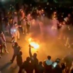 Um manifestante queima uma imagem de Ali Khamenei, Líder Supremo do Irã, durante um protesto em frente à embaixada iraniana em Londres, em 14 de janeiro.