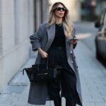 HAMBURGO, ALEMANHA - 7 DE MAIO: Laura Noltemeyer é vista vestindo jeans de perna larga azul índigo claro da Agolde, blusa de algodão com manga bufante e gravata na frente em branco com listras azuis da Sézane, óculos de sol pretos grandes de acetato olho de gato da Celine, bolsa Arco em couro intrecciato branco da Bottega Veneta, grandes brincos dourados em forma de gota, um pequeno relógio Lady-Datejust em ouro-prata da Rolex, uma pulseira LOVE dourada da Cartier, anéis de ouro empilhados da Cartier em 7 de maio de 2025 em Hamburgo, Alemanha. (Foto de Moritz Scholz/Getty Images)