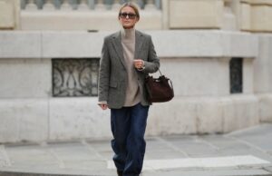 17 suéteres tipo caxemira que combinam com o estilo da mãe rica (menos de US $ 35!) Laura Noltemeyer é vista vestindo um suéter cinza de malha fina com gola frontal drapeada escultural da Zara; jeans de perna reta azul claro com desbotamento suave da Zara; botas de inverno em camurça bege com bico arredondado, atacadores de corda, costura tonal e sola de borracha grossa da Inuikii; uma grande bolsa de ombro marrom escuro texturizada em um formato escultural suave e desleixado e couro tecido da Les Visionnaires x Michi da Want; óculos de sol ovais pretos com armação em acetato brilhante e lentes escuras da Celine; brincos esculturais de ouro grossos da Zara; luvas de couro macio marrom escuro da Zara; seu cabelo castanho escuro está liso com uma divisão ao meio, preso atrás das orelhas em 25 de novembro de 2025 em Berlim, Alemanha.