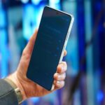 Samsung Galaxy S25 deitado de bruços sobre uma mesa com o logotipo da Samsung visível