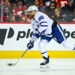 O ala direito do Toronto Maple Leafs, William Nylander (88), controla o disco contra o Calgary Flames durante o terceiro período no Scotiabank Saddledome.