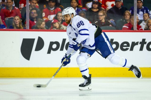 O ala direito do Toronto Maple Leafs, William Nylander (88), controla o disco contra o Calgary Flames durante o terceiro período no Scotiabank Saddledome.
