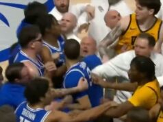 A briga VCU-Saint Louis começa após um movimento de coçar a cabeça na campainha Um jogador de basquete com camisa azul é afastado de um jogador adversário com camisa amarela, enquanto treinadores e outros jogadores tentam acalmar a situação.