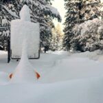 Uma pessoa segurando neve com a mão enluvada, demonstrando uma camada fraca na camada de neve que pode causar avalanches.
