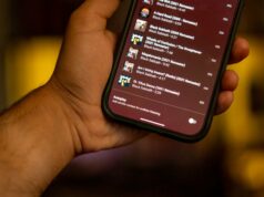 A configuração pouco conhecida do YouTube Music que corrigiu minhas playlists para sempre Homem curtindo música com fones de ouvido, com ícone de reprodução do YouTube Music, gráfico de onda sonora e a palavra Discover em negrito.