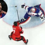 O goleiro dos EUA Connor Hellebuyck faz uma defesa impressionante sobre o canadense Devon Toews no terceiro período do jogo pela medalha de ouro olímpica em 22 de fevereiro de 2026.