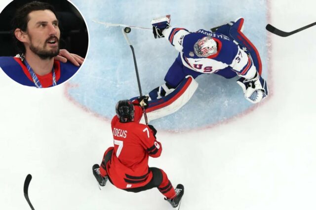 O goleiro dos EUA Connor Hellebuyck faz uma defesa impressionante sobre o canadense Devon Toews no terceiro período do jogo pela medalha de ouro olímpica em 22 de fevereiro de 2026.