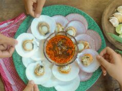 A disputa de ‘dupla imersão’ sobre os chips Qualcomm para iPhone finalmente termina A disputa de 'dupla imersão' sobre os chips Qualcomm para iPhone finalmente termina | Close de mãos pegando comida com um mergulho no centro do prato