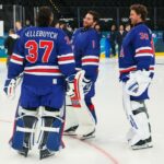 Connor Hellebuyck (à esquerda), Jeremy Swayman (ao meio) e Jake Oettinger no gelo de treino da equipe dos EUA nas Olimpíadas em 9 de fevereiro de 2026.