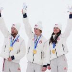 Os esquiadores de estilo livre Christopher Lillis, Kaila Kuhn e Connor Curran, dos Estados Unidos, comemoram a conquista da medalha de ouro enquanto Mengtao Xu, da China, assiste durante as Finais Aéreas de Equipes Mistas.