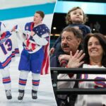 Auston Matthews #34, Zach Werenski #8 e Matthew Tkachuk #19 da equipe dos Estados Unidos comemoram a vitória e a medalha de ouro com uma camisa de Johnny Gaudreau durante a final do hóquei no gelo masculino entre EUA e Canadá no décimo sexto dia dos Jogos Olímpicos de Inverno Milano Cortina 2026 na Arena de Hóquei no Gelo Milano Santagiulia em 22 de fevereiro de 2026 em Milão, Itália.