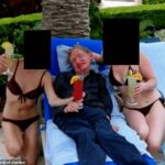As mulheres de biquíni que posaram com o professor Stephen Hawking nesta fotografia incluída nos arquivos de Epstein eram suas cuidadoras de longa data, afirmou a família Hawking.