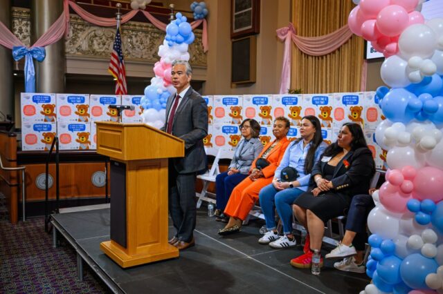 A vereadora da cidade de Oakland, Janani Ramachandran, segura seu filho Nilaan, de 1 ano, enquanto participava de uma coletiva de imprensa comemorando o lançamento de 