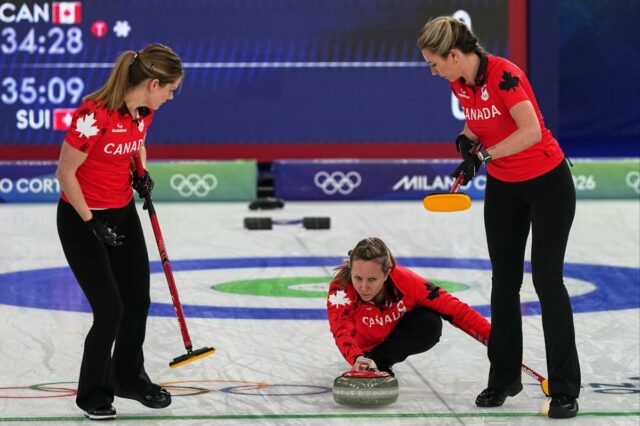 Arah Wilkes, Rachel Homan e Emma Miskew do Canadá em ação durante o round robin de curling feminino contra a Suíça nos Jogos Olímpicos de Inverno de 2026, em Cortina d'Ampezzo, Itália, sábado, 14 de fevereiro de 2026. 
