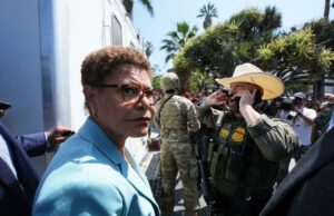 A revolta de esquerda que Karen Bass nunca imaginou chegar A prefeita de Los Angeles, Karen Bass, falando em um pódio com o selo da cidade.