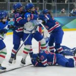 Hannah Bilka (23), dos Estados Unidos, se cobre enquanto jogadores se acotovelam acima dela depois que ela marcou um gol durante o segundo período de uma partida das quartas de final de hóquei no gelo feminino nos Jogos Olímpicos de Inverno de 2026, em Milão, Itália, sexta-feira, 13 de fevereiro de 2026.