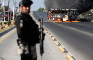 A violência irrompe após o líder do cartel mexicano “El Mencho” ser morto em operação federal Um membro do Ministério Público monta guarda perto de um ônibus em chamas incendiado por grupos do crime organizado em resposta a uma operação em Jalisco para prender um alvo de segurança de alta prioridade, em uma das principais avenidas de Zapopan, estado de Jalisco, México, em 22 de fevereiro de 2026. / Crédito: Ulises Ruiz /AFP via Getty Images