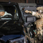 Agentes federais estão do lado de fora de uma loja de conveniência na quarta-feira, 21 de janeiro de 2026, em Minneapolis. (Foto AP/Angelina Katsanis)