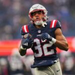 Treveyon Henderson vestindo um moletom do New England Patriots e um passe de imprensa pré-semana do Super Bowl LIX.