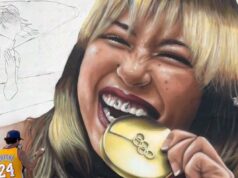 Alysa Liu homenageada com enorme mural em Los Angeles após sucesso olímpico Alysa Liu mordendo sua medalha de ouro na Cerimônia de Vitória da Patinação Individual Feminina.