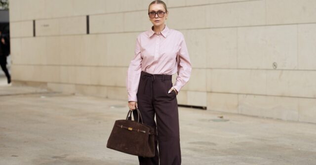 PARIS, FRANÇA - 12 DE JANEIRO: Maria Rosaria Rizzo usa longos cabelos castanhos soltos e repartidos ao centro, óculos de sol Saint Laurent com lentes escuras, uma bolsa Pinel et Pinel preta e branca com formato retangular estruturado em couro com logotipo do monograma impresso e alças superiores duplas transportadas à mão, um suéter de malha Marella preto com decote redondo, uma jaqueta Akep cortada em um padrão texturizado preto e branco com lapelas largas e fecho de botão frontal usado sobre os ombros, preto Calça de alfaiataria Balmain com perna reta, sapatilhas de couro preto Salvatore Ferragamo com bico arredondado, detalhe dourado e sola discreta, durante sessão de fotos de moda street style, no dia 12 de janeiro de 2026 em Paris, França. (Foto de Edward Berthelot/Getty Images)