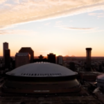 Estádio Caesars Super Bowl, vista aérea. Sol se pondo ao longe.