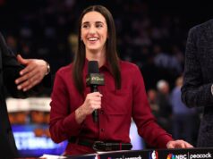 Caitlin Clark dá uma perspectiva otimista enquanto as negociações do CBA da WNBA atingem um momento crítico Caitlin Clark sorri enquanto segura um microfone com o logotipo da NBC Sports, em um palco com outras pessoas, falando em um evento.