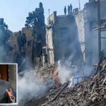 Danos em local de impacto em Teerã com fumaça e fogo.