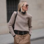 Leo Eberlin é visto usando óculos de sol tipo gatinho sem aro com lentes laranja e armação superior cinza estruturada de & Other Stories; duas peças marrons da Arket, composta por jaqueta com carcela de botões marrom escuro, gola e bolsos grandes no peito, calça larga com vinco; uma bolsa “Kelly” de couro bege da Hermès; e salto alto pontudo de couro marrom de Christian Loubouti em 03 de outubro de 2024 em Berlim, Alemanha.