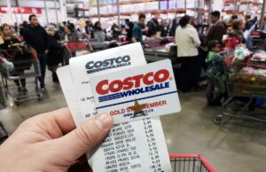 Centenas de cartões-presente da Costco não são mais válidos – veja como obter o reembolso total deles Uma mão segurando um cartão Costco Gold Star Member em frente a uma placa borrada da loja Costco Wholesale.