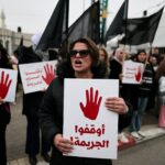 Pessoas seguram cartazes e acendem lanternas em seus telefones durante uma manifestação contra o aumento dos índices de criminalidade contra árabes-israelenses em Tel Aviv, em 31 de janeiro de 2026. (Foto de AHMAD GHARABLI / AFP)