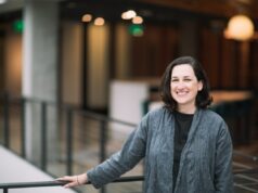 Como a IA muda a matemática das startups, de acordo com um vice-presidente da Microsoft A dark-haired woman poses by a balcony in a gray cardigan sweater.