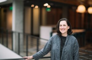 Como a IA muda a matemática das startups, de acordo com um vice-presidente da Microsoft A dark-haired woman poses by a balcony in a gray cardigan sweater.