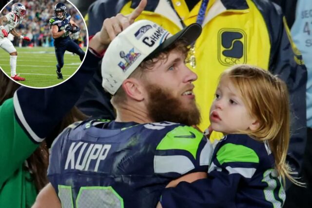Cooper Kupp, do Seattle Seahawks, com boné e camisa de campeonato, segurando sua filha com sua esposa Anna Croskrey parcialmente visíveis atrás dele.