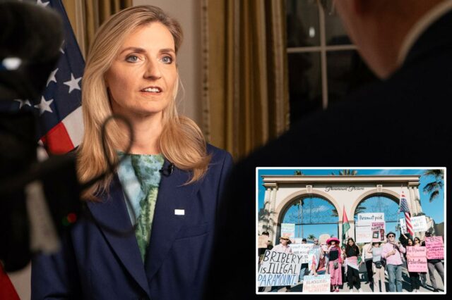 A subsecretária Rogers falando ao microfone com uma bandeira americana atrás dela.