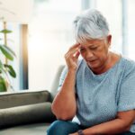 Mulher adicionando açúcar a uma xícara de café.
