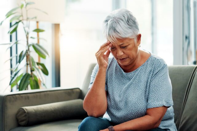 Mulher adicionando açúcar a uma xícara de café.