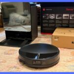 Roborock S7 MaxV Ultra robô aspirador e estação de acoplamento com um smartphone mostrando um aplicativo.