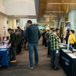 Pessoas interagindo com recrutadores na WorkSource North Seattle Career Fair.