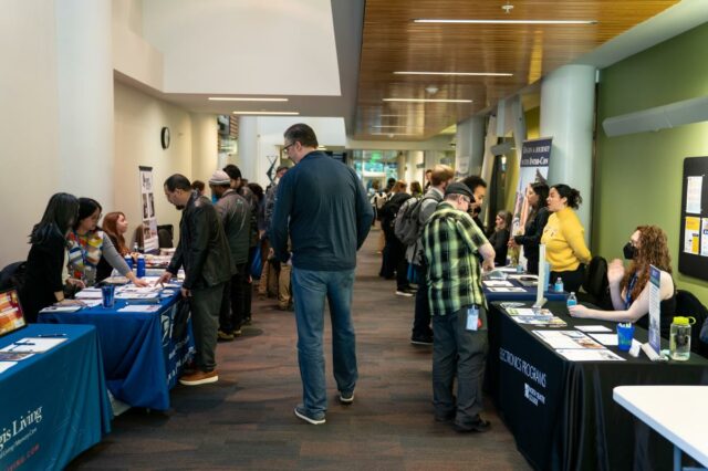 Pessoas interagindo com recrutadores na WorkSource North Seattle Career Fair.